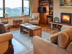 a living room with couches and a fireplace at Brandystone Cottage in Oban