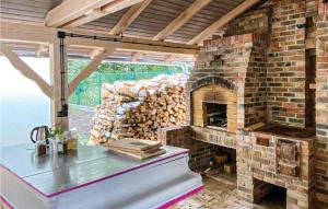 uma cozinha com lareira de tijolos numa casa em Cozy Home In Wilcze With Lake View em Wilcze