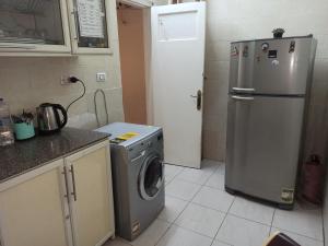 a kitchen with a washing machine and a refrigerator at Golden Star Hostel in Cairo
