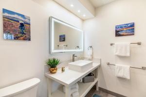 a white bathroom with a sink and a mirror at RARE Upscale Oasis - 2 Bed,2 Bath - Kuau Plaza - Paia in Paia