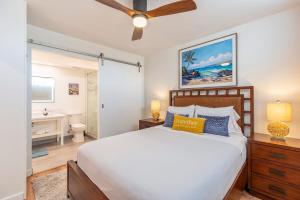 a bedroom with a large bed and a bathroom at RARE Upscale Oasis - 2 Bed,2 Bath - Kuau Plaza - Paia in Paia