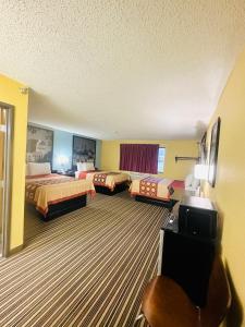 a hotel room with two beds and a television at Super 8 by Wyndham Warrenton in Warrenton