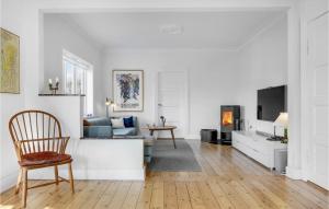 uma sala de estar branca com um sofá e uma cadeira em Nice Home In Dyssegrd With Wifi And 5 Bedrooms em Søborg