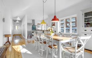 - une cuisine blanche avec une table et des chaises en bois dans l'établissement Beautiful Home In Dyssegrd With Kitchen, à Søborg