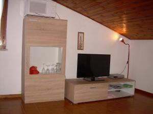 a living room with a television on a wooden stand at Casa Mary in Brenzone sul Garda