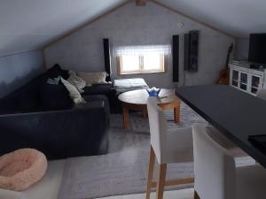 ein Wohnzimmer mit einem Sofa und einem Tisch in der Unterkunft Holiday home GRISSLEHAMN XII in Grisslehamn