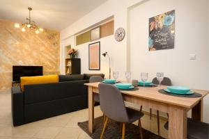 un soggiorno con tavolo e divano di Corfu PRIME Apartments a Città di Corfù