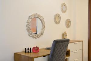 una scrivania con sedia e uno specchio sul muro di Corfu PRIME Apartments a Città di Corfù