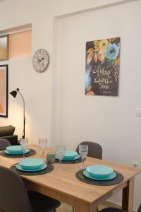 un tavolo in legno con piatti e bicchieri da vino sopra di Corfu PRIME Apartments a Città di Corfù