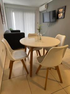 y sala de estar con mesa de comedor y sillas. en Departamento Entero con Pileta Calasanzs en Córdoba