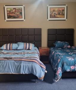 a bedroom with two beds and two pictures on the wall at CASA HOSPEDAJE LA FLORIDA in Cusco