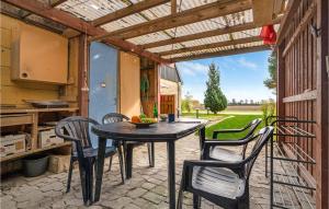 patio con mesa y sillas y cocina en Gorgeous Home In Bandholm With Kitchen, en Bandholm