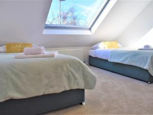 a attic bedroom with two beds and a window at Puffin House in Belford