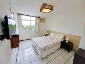 1 dormitorio con 1 cama y TV en GRAN LENÇÓIS FLAT RESIDENCE, en Barreirinhas