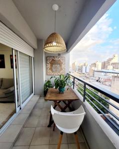 - Balcón con mesa de madera y silla en Dpto. nuevo, luminoso, 3 dormitorios, pleno centro en Rosario