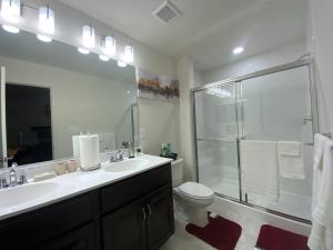 a bathroom with a toilet and a sink and a shower at Apple House- New Townhouse - 2 Car Garage by CCBC & Franklin Sq in Rosedale