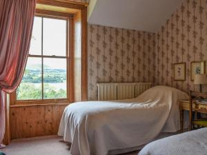 a bedroom with a bed and a window at Sharrow Cottage in Watermillock