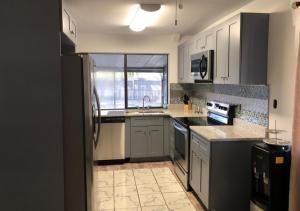 a kitchen with white cabinets and a black refrigerator at Comfy Beautiful 3 bedroom Home in Jacksonville in Jacksonville