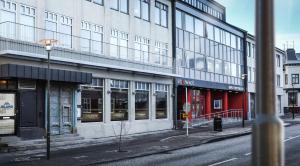 eine Stadtstraße mit einem großen Gebäude mit Fenstern in der Unterkunft Island Apartments in Reykjavík