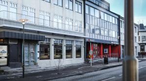 a city street with a large building with windows at Island Apartments in Reykjavík