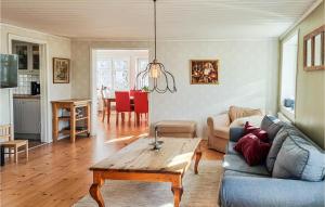 uma sala de estar com um sofá e uma mesa em Cozy Home In Svanesund With Kitchen em Svanesund