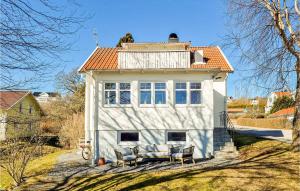 een wit huis met stoelen ervoor bij Cozy Home In Svanesund With Kitchen in Svanesund