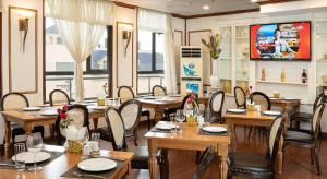 a restaurant with wooden tables and chairs and a tv at Affa Boutique Hotel in Hanoi