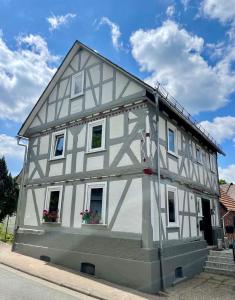 ein weißes Haus mit schwarz-weiß in der Unterkunft Rosehill Cottage 1699 - Stilvolle Ferien Berge & Seen 