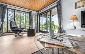 ein Wohnzimmer mit einem Glastisch und einem Stuhl in der Unterkunft Beautiful Home In Bog By With Kitchen in Bogø By