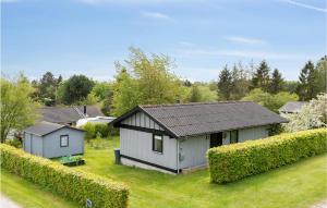 una pequeña casa en un patio con arbustos en Beautiful Home In Bog By With Kitchen en Bogø By