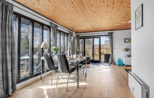 comedor con mesa, sillas y ventanas en Beautiful Home In Bog By With Kitchen en Bogø By