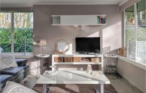 2 Bedroom Gorgeous Home In Rekem-lanaken في Bovenwezet: غرفة معيشة مع طاولة بيضاء وتلفزيون