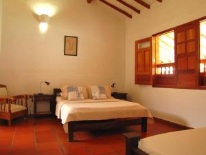a bedroom with a bed and a table and a window at La Casa de Hercilia Boutique in Barichara