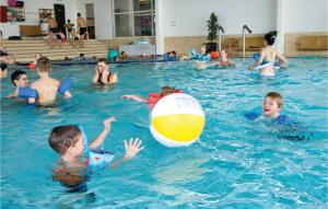 een groep kinderen die met een bal spelen in een zwembad bij 4 Bedroom Awesome Home In Grsten in Gråsten