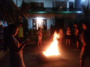 grupa ludzi stojących wokół ogniska w nocy w obiekcie Ella Jayamali Homestay w mieście Ella