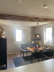 - une salle à manger avec une table, des chaises et 2 fenêtres dans l'établissement Rosehill Cottage 1699 - Stilvolle Ferien Berge & Seen, 