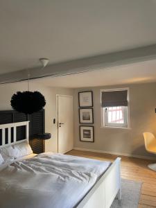 1 dormitorio con cama blanca y ventana en Rosehill Cottage 1699 - Stilvolle Ferien Berge & Seen, 