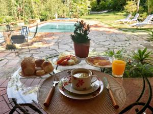 a table with breakfast food and a cup of coffee at Pousada Valle Paradiso in Itaipava