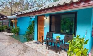 a blue house with a bench and a table at Farm Madame Fleur in Cha Am