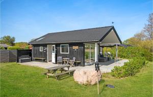 uma pequena casa preta com uma mesa de piquenique e um banco em 1 Bedroom Nice Home In Grlev em Gørlev