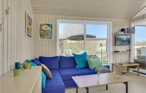 uma sala de estar com um sofá azul e uma mesa em 1 Bedroom Nice Home In Grlev em Gørlev