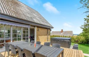 a patio with a wooden table and chairs at Awesome Home In Allinge With 5 Bedrooms And Wifi in Allinge