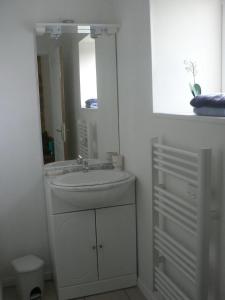 a white bathroom with a sink and a mirror at Domaine des Cigognes - Gîte les Roseaux in Écrammeville