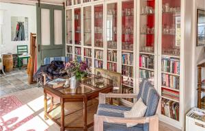 una habitación con una mesa y una estantería con libros en Awesome Home In Kosta With Kitchen en Kosta