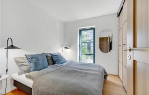 a white bedroom with a bed and a window at 3 Bedroom Nice Apartment In Kerteminde in Kerteminde