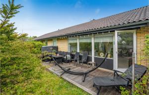 a deck with chairs and a table on a house at 4 Bedroom Lovely Home In Frederikshavn in Frederikshavn