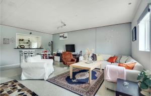 een woonkamer met witte meubels en een tafel bij 4 Bedroom Lovely Home In Frederikshavn in Frederikshavn