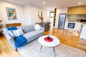 a living room with a couch and a table at 2 bed paradise near Hagley Park in Christchurch