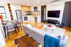 a living room with a couch and a tv and a table at 2 bed paradise near Hagley Park in Christchurch