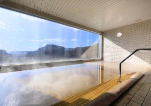 basen w budynku z dużym oknem w obiekcie Katsuura Hilltop Hotel & Residence w mieście Katsu’ura